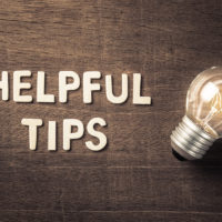 Helpful Tips caption to the left of glowing lightbulb on wood Helpful Tips caption to the left of glowing lightbulb on wood
