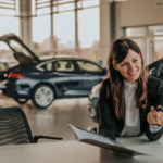 Woman talking to car manufacturer or dealer Woman talking to car manufacturer or dealer