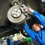 auto mechanic at car brake shoes examining