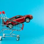 car loan concept. red car shopping cart blue background
