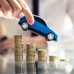 Person Flying Car Over Declining Stacked Coins