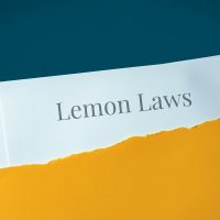Lemon Laws. Hand opens envelope and takes out documents. Post letter labeled with text