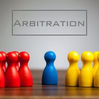Arbitration concept with pawn figurines on table, grey background Arbitration concept with pawn figurines on table, grey background