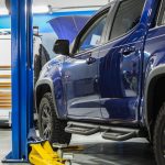 Blue Modern Pickup Truck Scheduled Maintenance Inside Dealership Auto Service Area. Automotive Industry Theme.